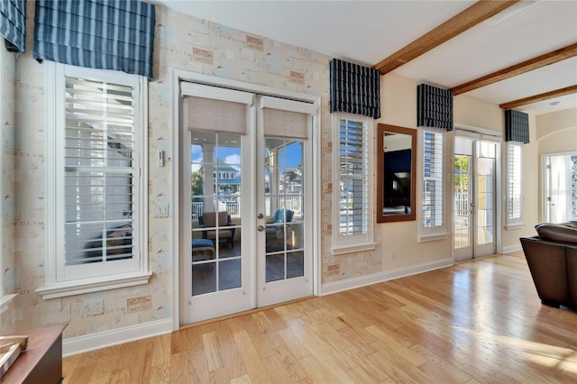 doorway to outside featuring light hardwood / wood-style floors, french doors, and beamed ceiling