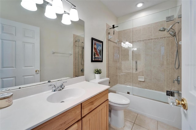 full bathroom featuring toilet, vanity, tile patterned floors, and combined bath / shower with glass door