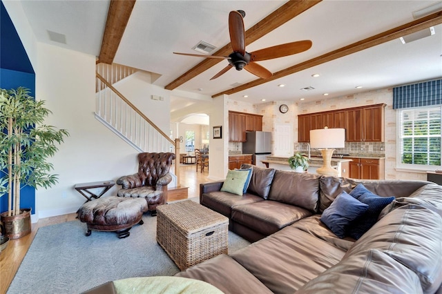 living room with beam ceiling, ceiling fan, and light hardwood / wood-style floors