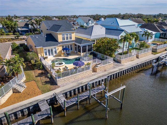 rear view of property with a patio, a water view, and a fenced in pool