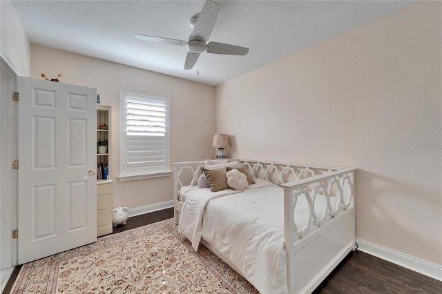 bedroom with dark hardwood / wood-style flooring and ceiling fan