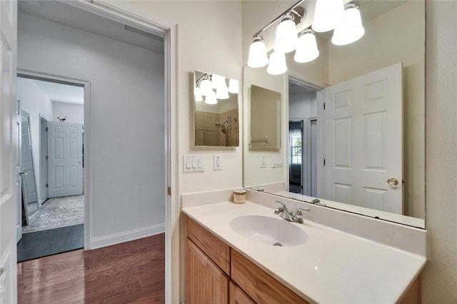 bathroom with hardwood / wood-style flooring, a notable chandelier, and vanity