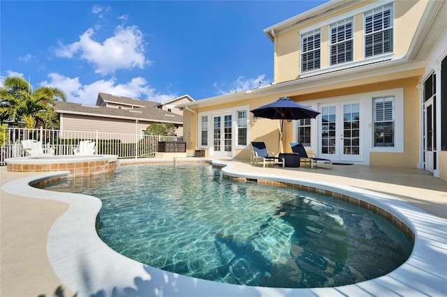 view of swimming pool with french doors and a patio