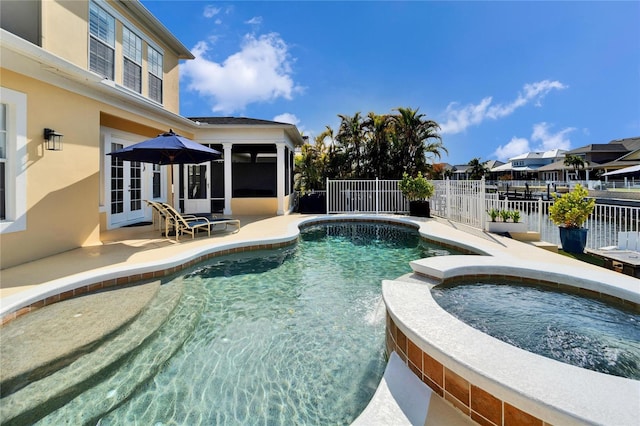 view of pool featuring a patio, french doors, an in ground hot tub, and a sunroom