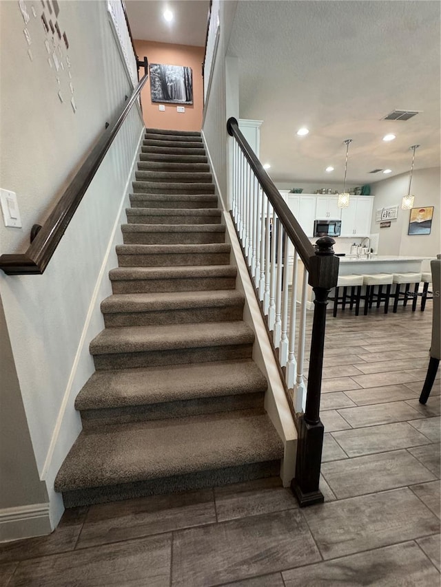 staircase featuring a chandelier