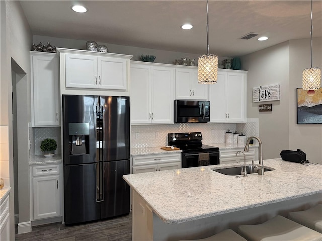 kitchen with black appliances, white cabinets, decorative light fixtures, and sink