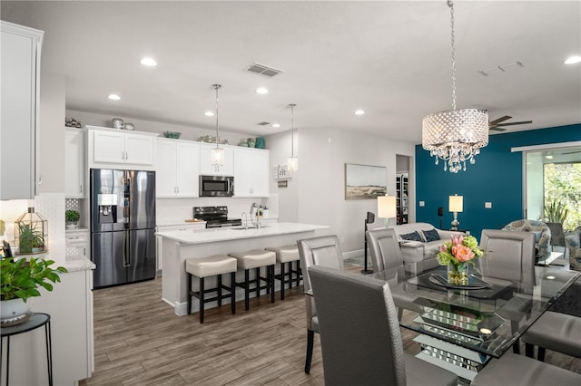 dining space featuring hardwood / wood-style flooring, an inviting chandelier, and sink