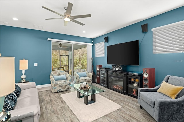 living room featuring light hardwood / wood-style flooring and ceiling fan