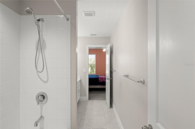 bathroom with a tile shower and tile patterned floors