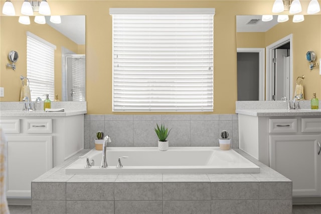 bathroom featuring vanity, shower with separate bathtub, and a chandelier