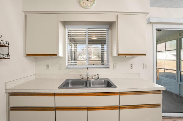 kitchen featuring white cabinetry and sink