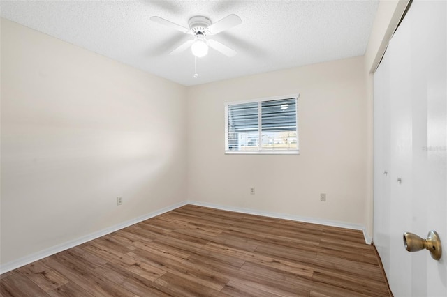 spare room with hardwood / wood-style flooring, ceiling fan, and a textured ceiling