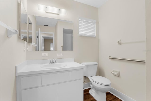 bathroom with hardwood / wood-style flooring, vanity, and toilet