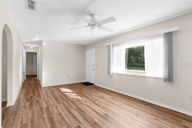 empty room featuring ceiling fan, a textured ceiling, and light hardwood / wood-style flooring