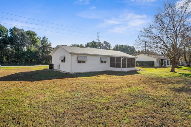 view of home's exterior featuring a sunroom, cooling unit, and a yard