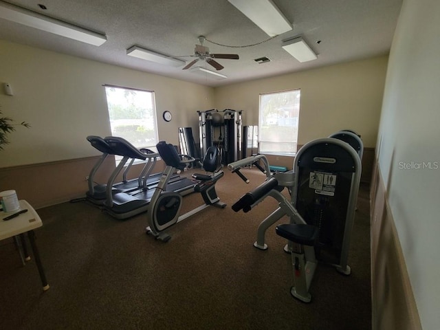 exercise room with a textured ceiling and ceiling fan