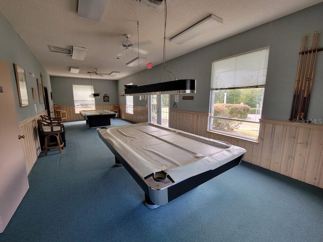 rec room with wooden walls, ceiling fan, a textured ceiling, and pool table