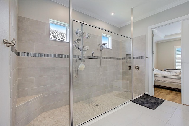 bathroom featuring a tile shower, tile patterned floors, plenty of natural light, and ornamental molding