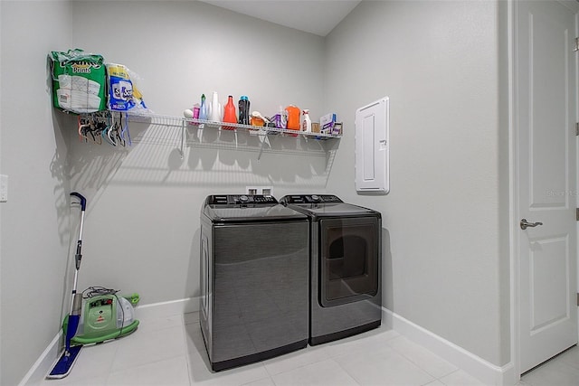 laundry area with light tile patterned floors, electric panel, and separate washer and dryer