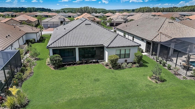 back of property featuring a lawn and a lanai