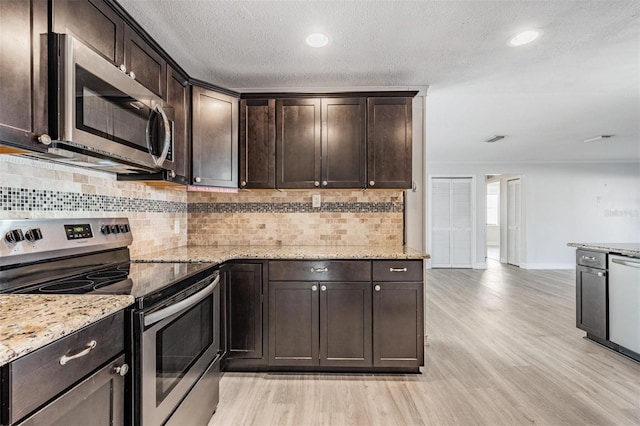 kitchen featuring light wood-type flooring, decorative backsplash, stainless steel appliances, and dark brown cabinetry