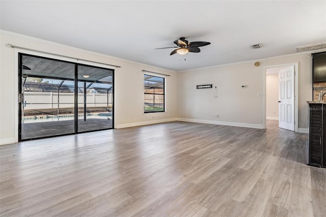 unfurnished living room with light wood-type flooring, ceiling fan, and crown molding