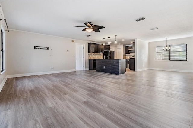 unfurnished living room featuring ceiling fan with notable chandelier and hardwood / wood-style floors