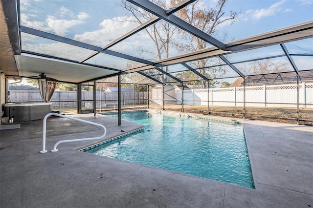 view of swimming pool with glass enclosure, a patio area, and a storage shed