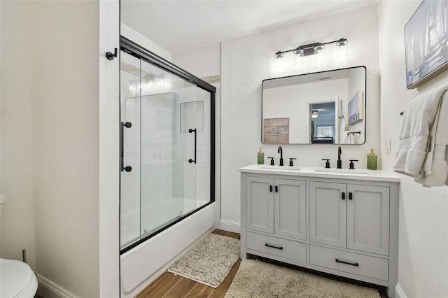 full bathroom with vanity, enclosed tub / shower combo, and toilet