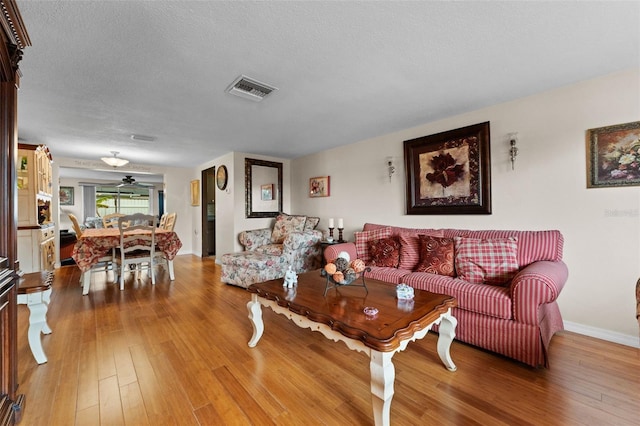 living room with hardwood / wood-style floors and a textured ceiling