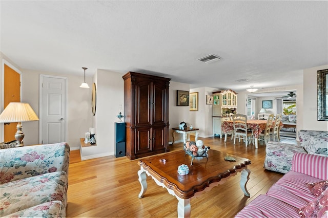 living room featuring ceiling fan and light hardwood / wood-style floors