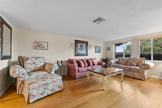 living room with wood-type flooring and a textured ceiling