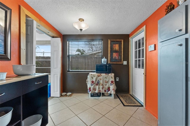 interior space featuring light tile patterned floors and a textured ceiling