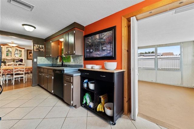 kitchen with dark brown cabinetry, dishwasher, sink, a textured ceiling, and decorative backsplash