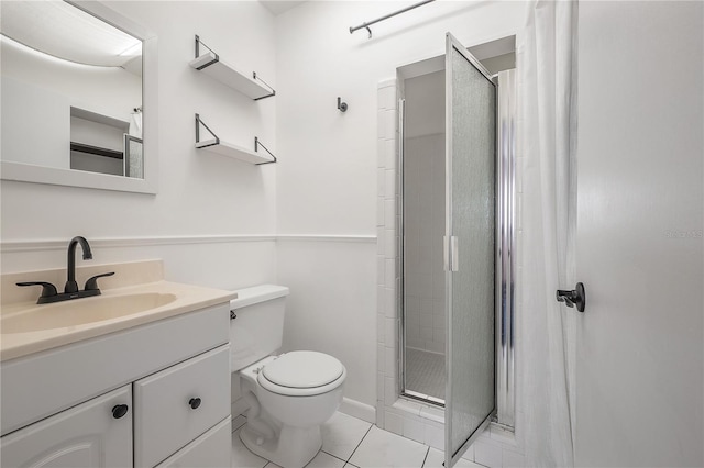 bathroom with vanity, tile patterned flooring, toilet, and walk in shower