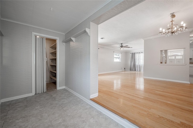 empty room featuring ornamental molding and ceiling fan with notable chandelier