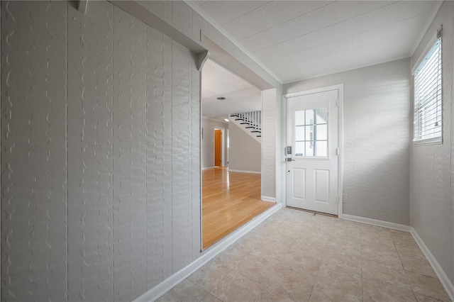 doorway to outside with ornamental molding and light hardwood / wood-style floors