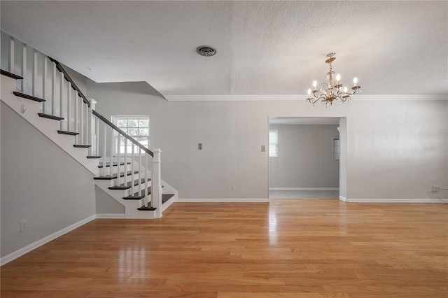 interior space with crown molding, a healthy amount of sunlight, and light wood-type flooring