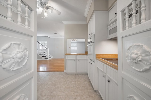 kitchen with crown molding, white cabinets, white appliances, and light hardwood / wood-style flooring