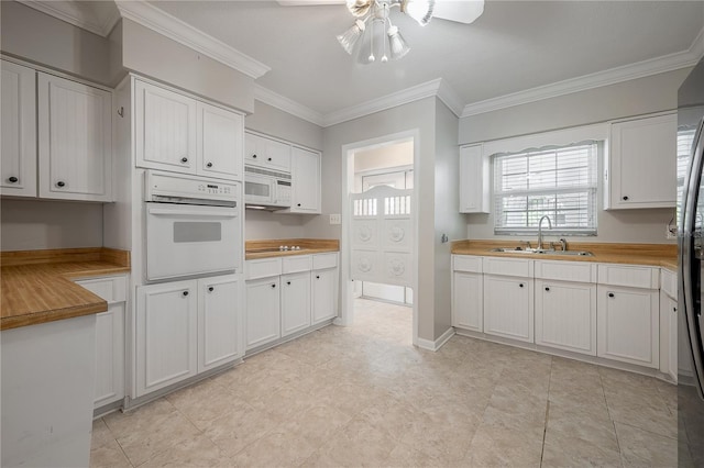 kitchen featuring white cabinetry, sink, white appliances, and butcher block countertops