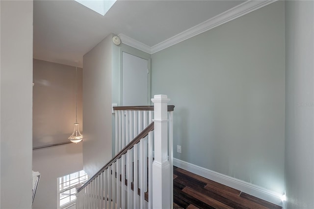 stairs featuring hardwood / wood-style flooring, ornamental molding, and a skylight