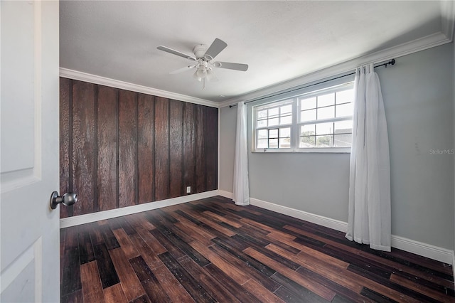 empty room with crown molding, dark wood-type flooring, and ceiling fan