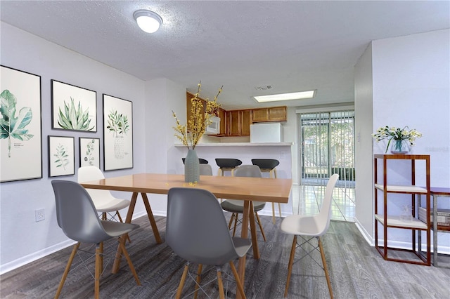 dining room featuring hardwood / wood-style floors and a textured ceiling