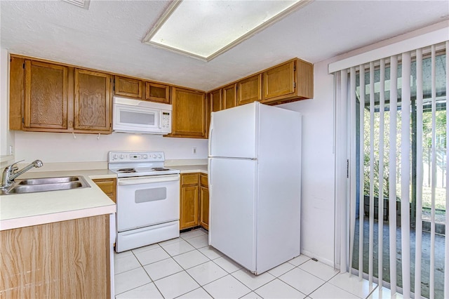 kitchen with light tile patterned floors, white appliances, and sink