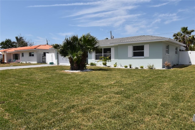 123 9th St, Belleair Beach, FL 33786 - ranch-style house featuring fence, driveway, a front lawn, and stucco siding