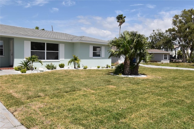 123 9th St, Belleair Beach, FL 33786 - ranch-style house featuring stucco siding and a front lawn
