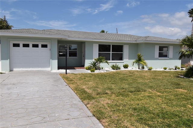 123 9th St, Belleair Beach, FL 33786 - ranch-style house with stucco siding, concrete driveway, a front yard, and a garage