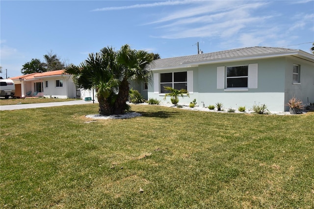 123 9th St, Belleair Beach, FL 33786 - ranch-style house featuring a front lawn and stucco siding