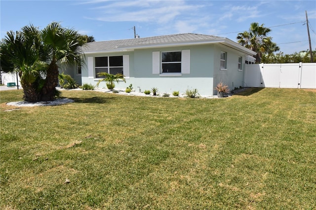 123 9th St, Belleair Beach, FL 33786 - view of side of property featuring a gate, a yard, stucco siding, and fence