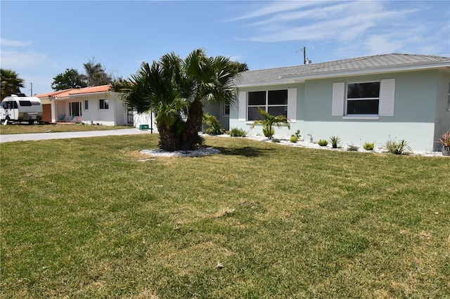 123 9th St, Belleair Beach, FL 33786 - ranch-style house with a front lawn and stucco siding